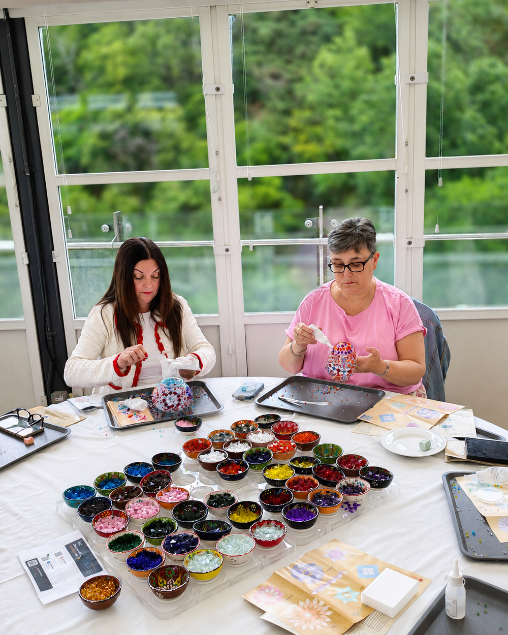 Instrutora da Atelier Hub a ensinar duas makers a decorar as suas lâmpadas em mosaico